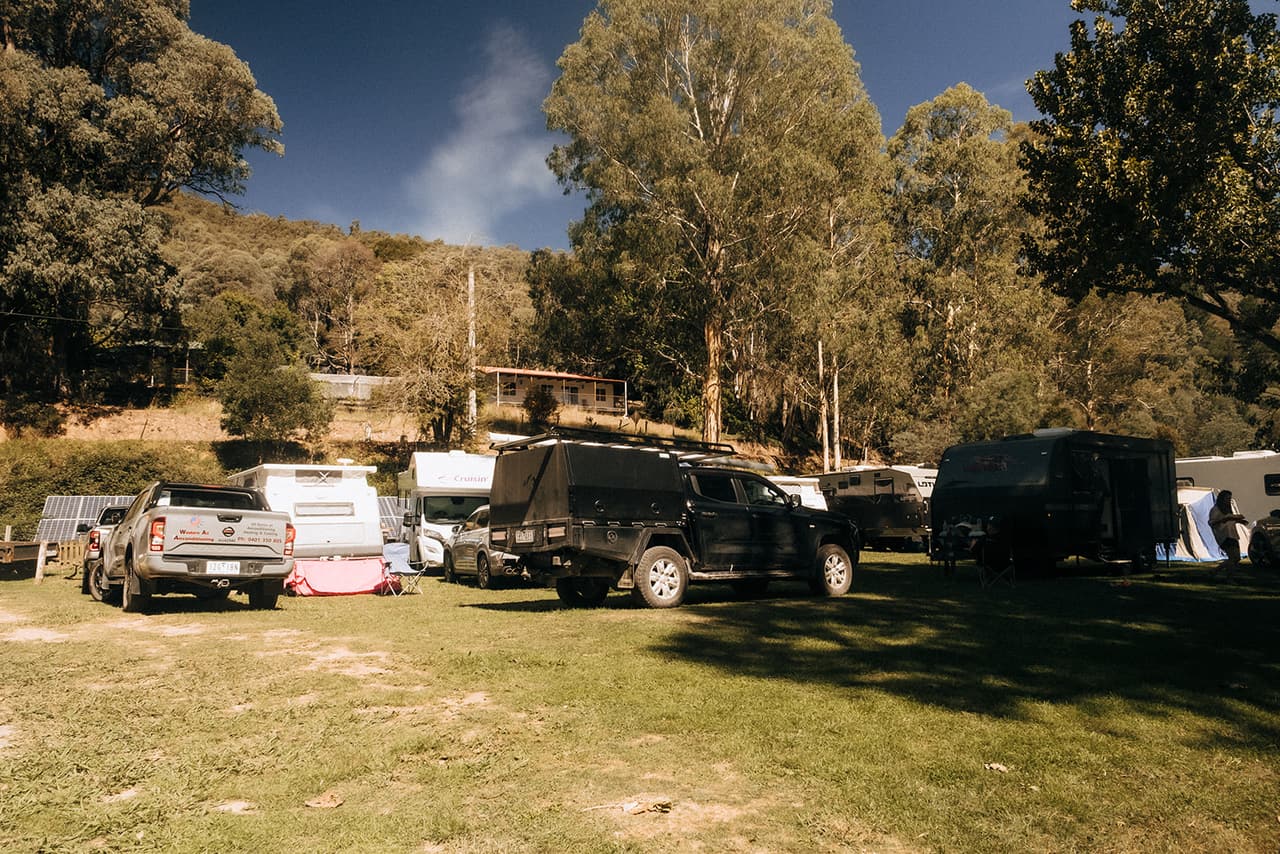 Guests' cars, caravans and tents among the trees beside the hotel