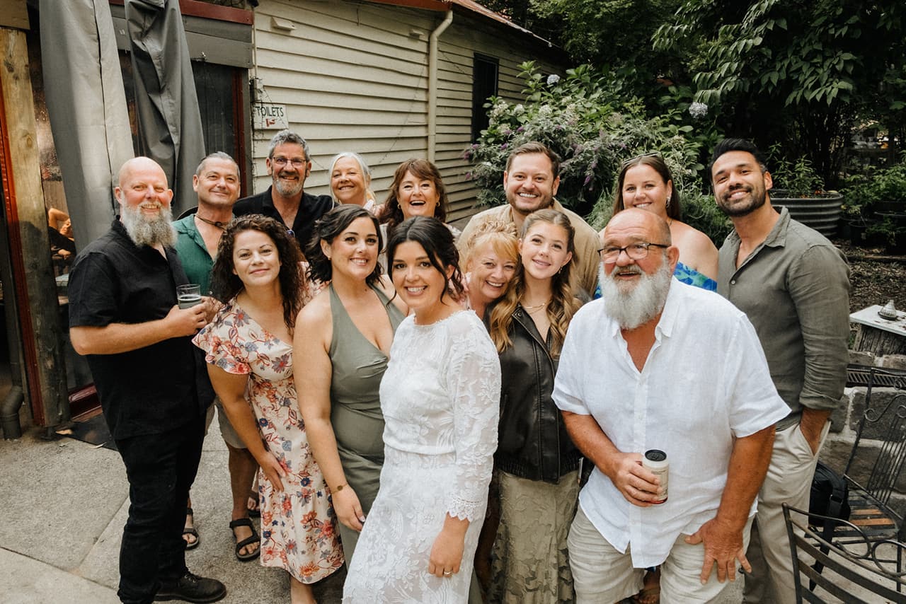 Lana surrounded by a big group of friends outside the hotel, everyone grinning