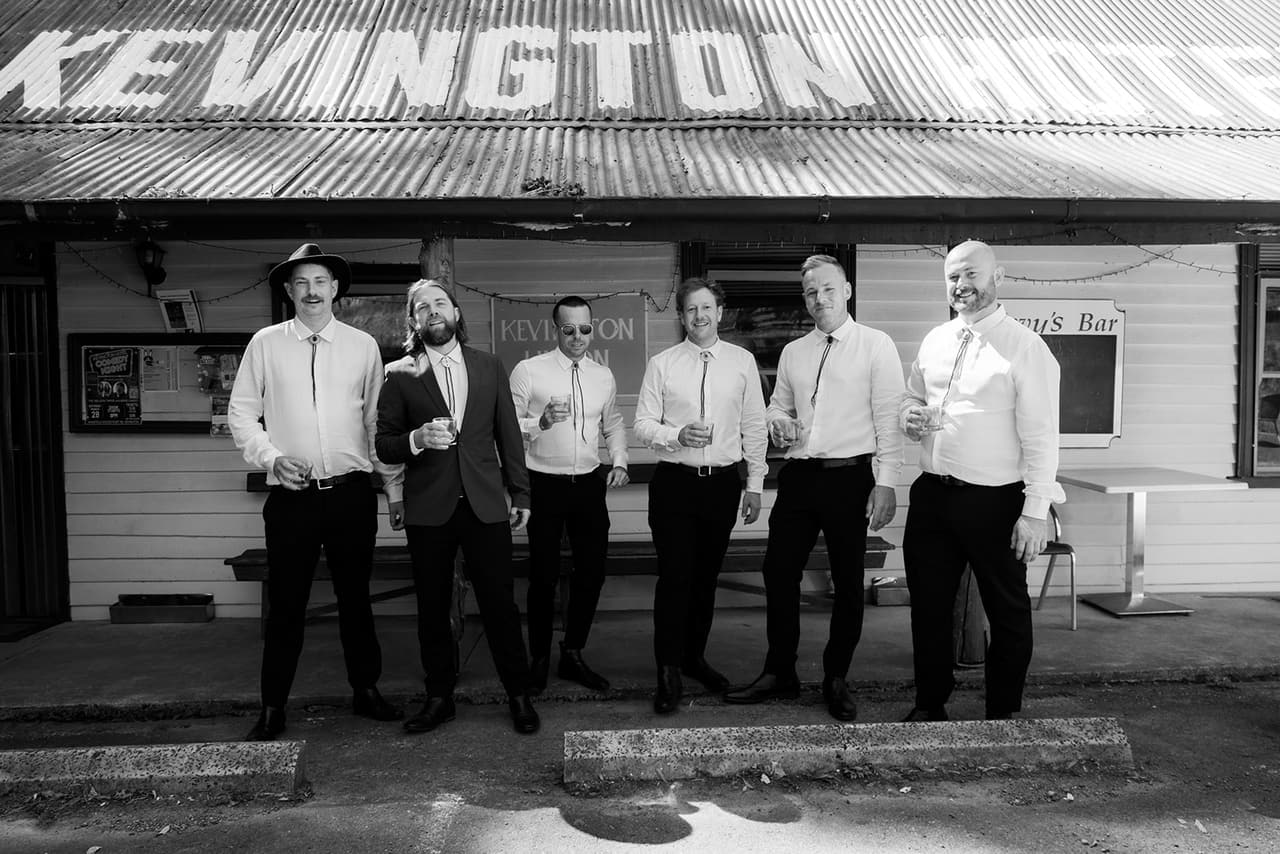 Todd and his groomsmen in front of the Kevington Hotel's painted sign