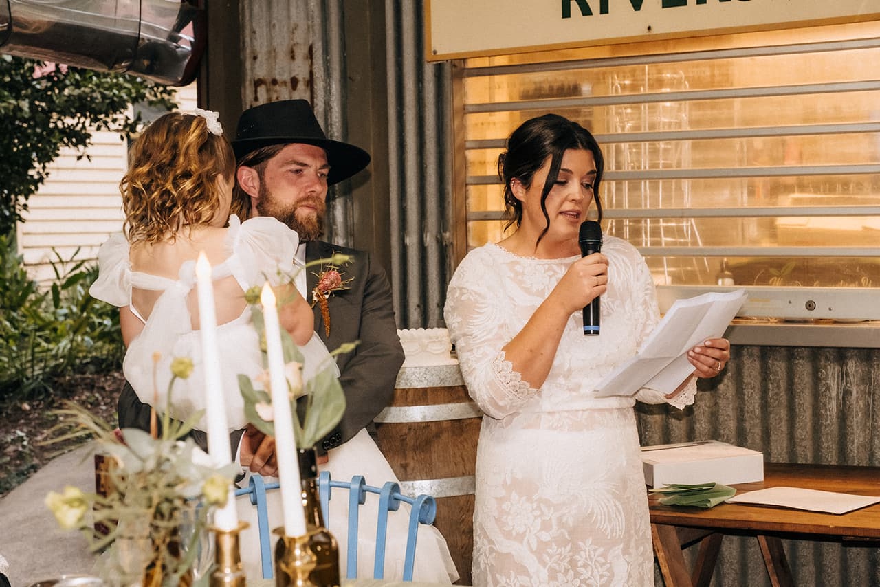 Lana giving her speech, Todd and a flower girl behind her