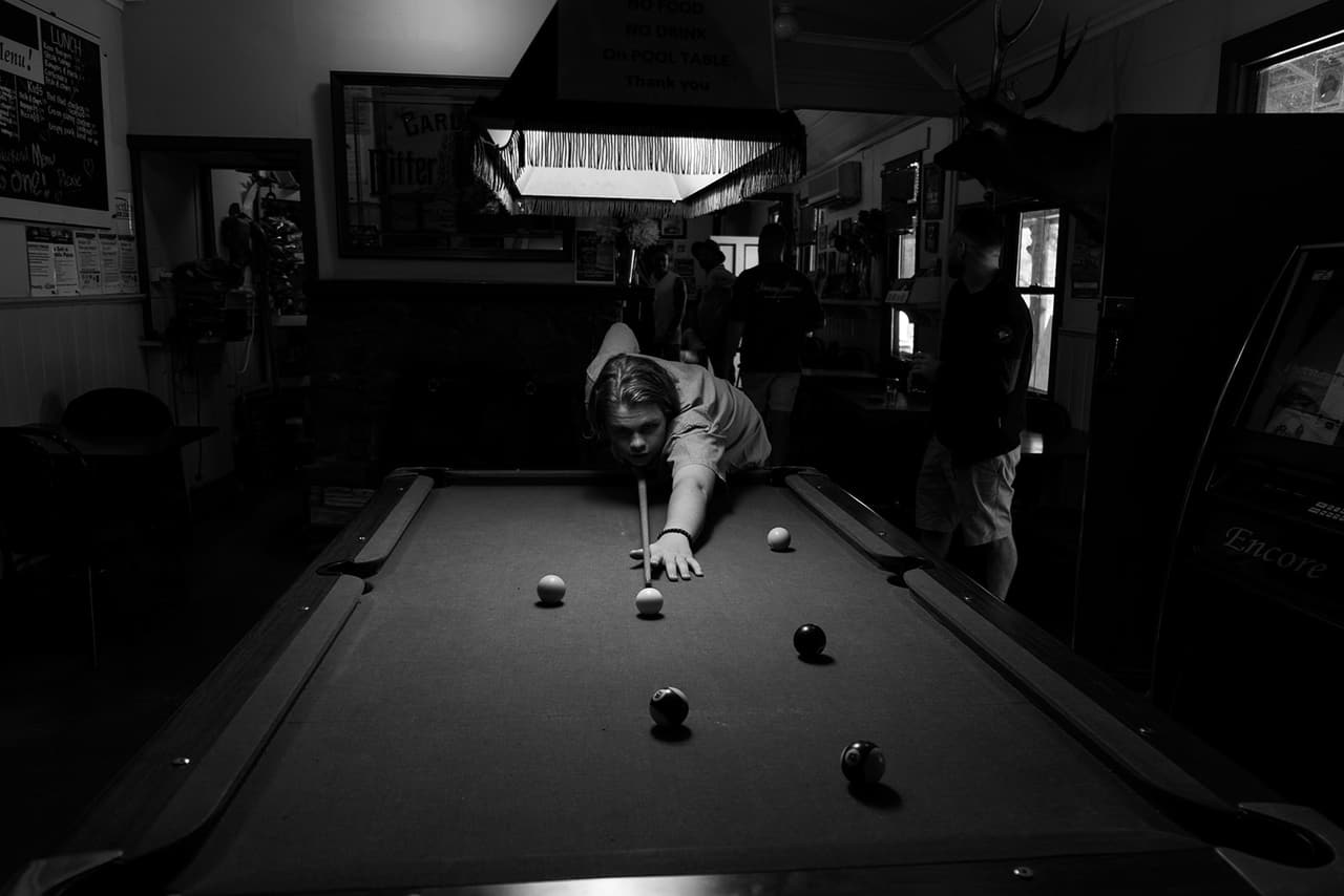 Black and white photo of a game of pool inside the old pub