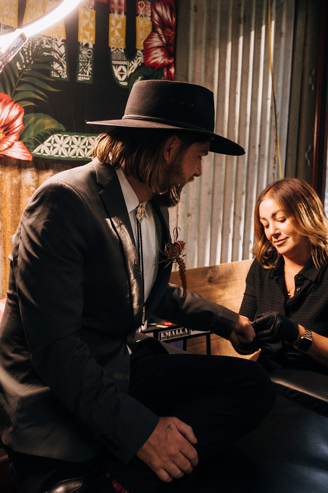Todd, still in his hat, getting a tattoo from the mobile tattoo artist