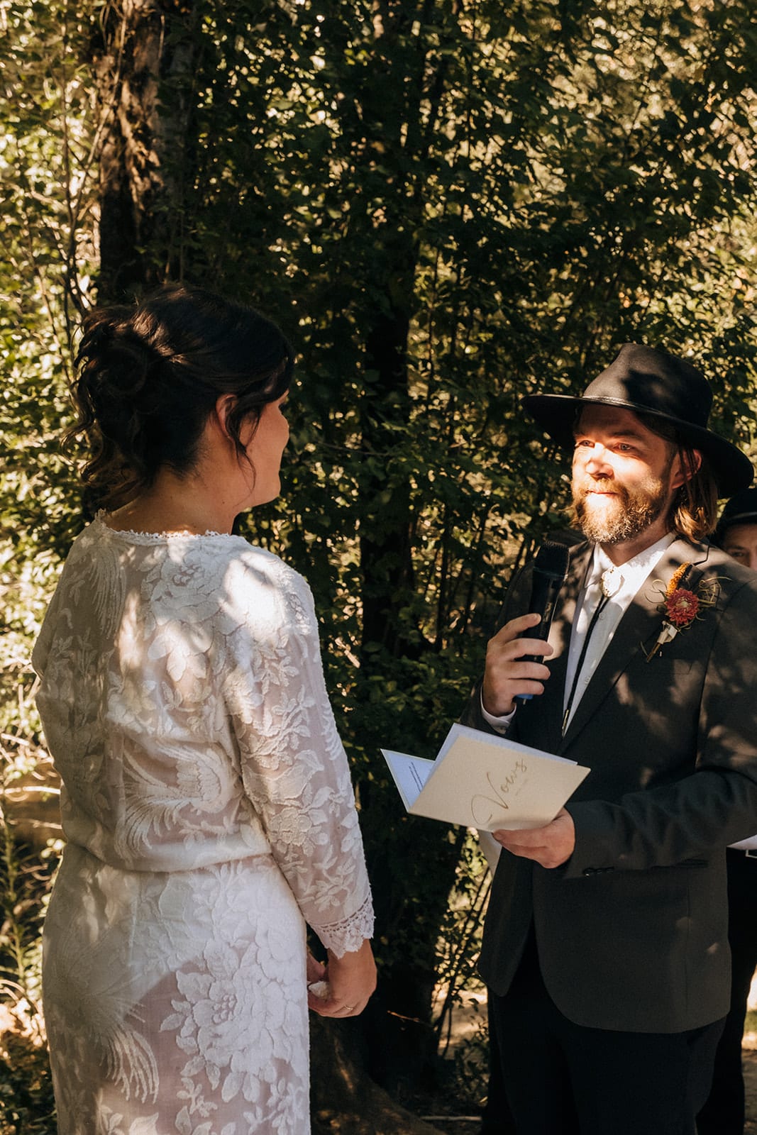 Todd reading his vows to Lana into a microphone, smiling under his hat
