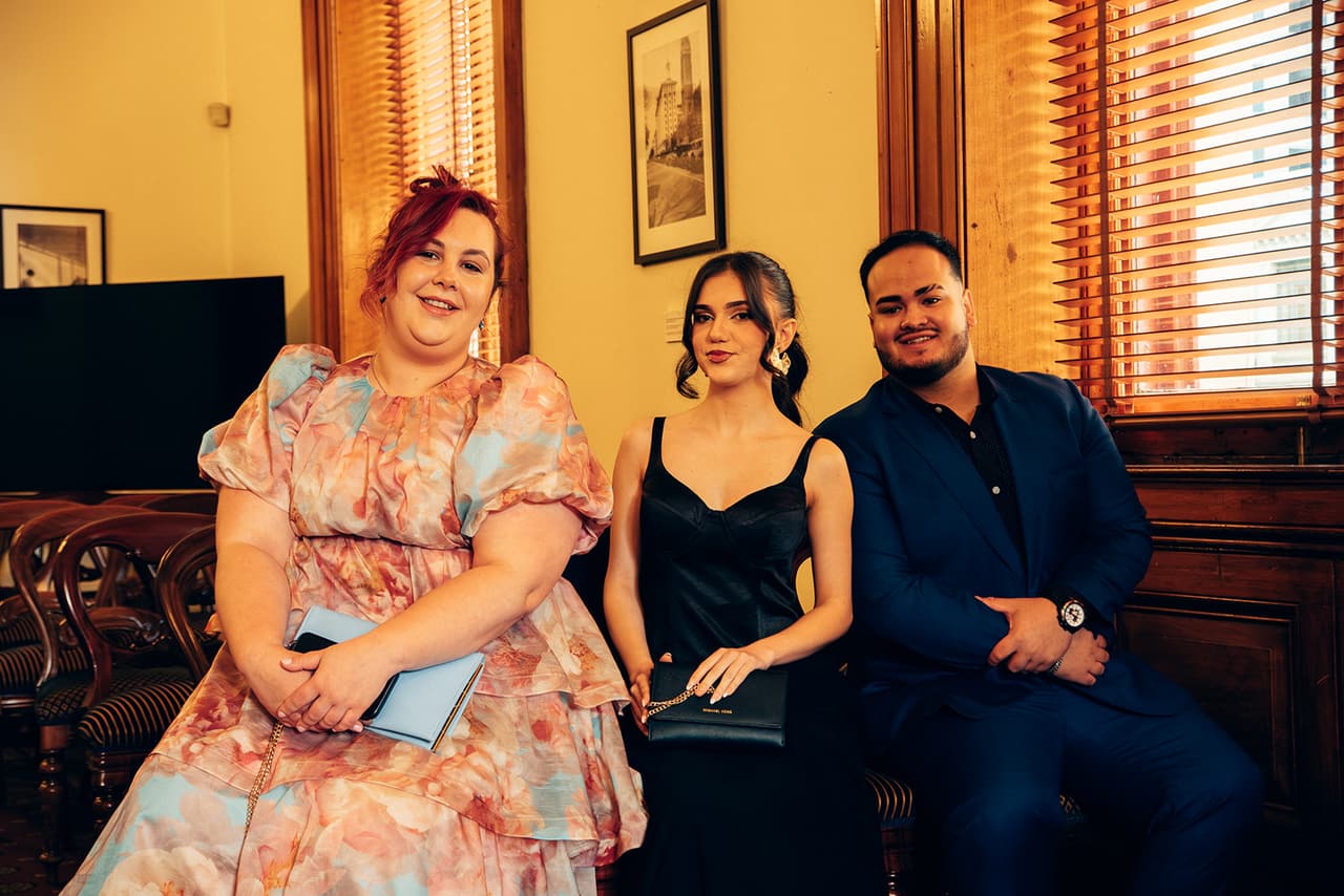 Three guests smiling from their chairs in the ceremony room before the ceremony