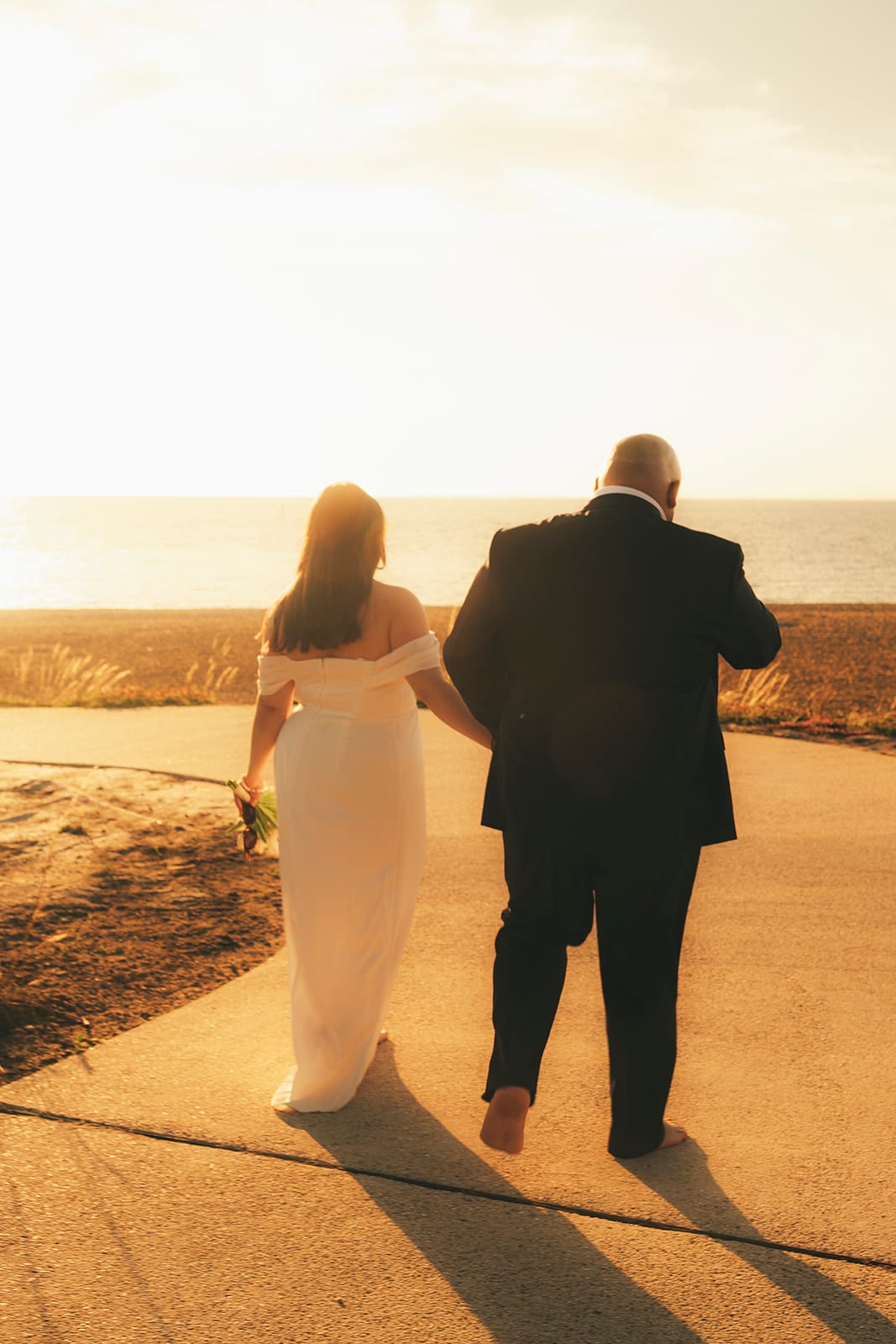 Martina and Diego walking down a path towards the setting sun