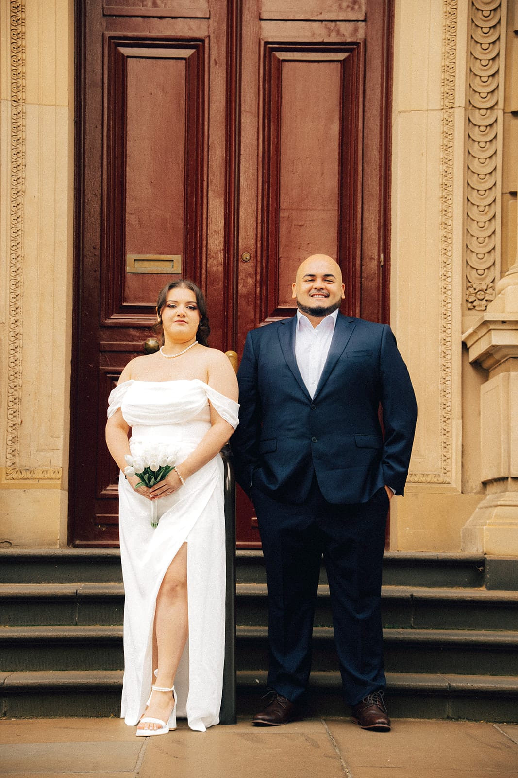 Martina and Diego in front of a tall red timber door