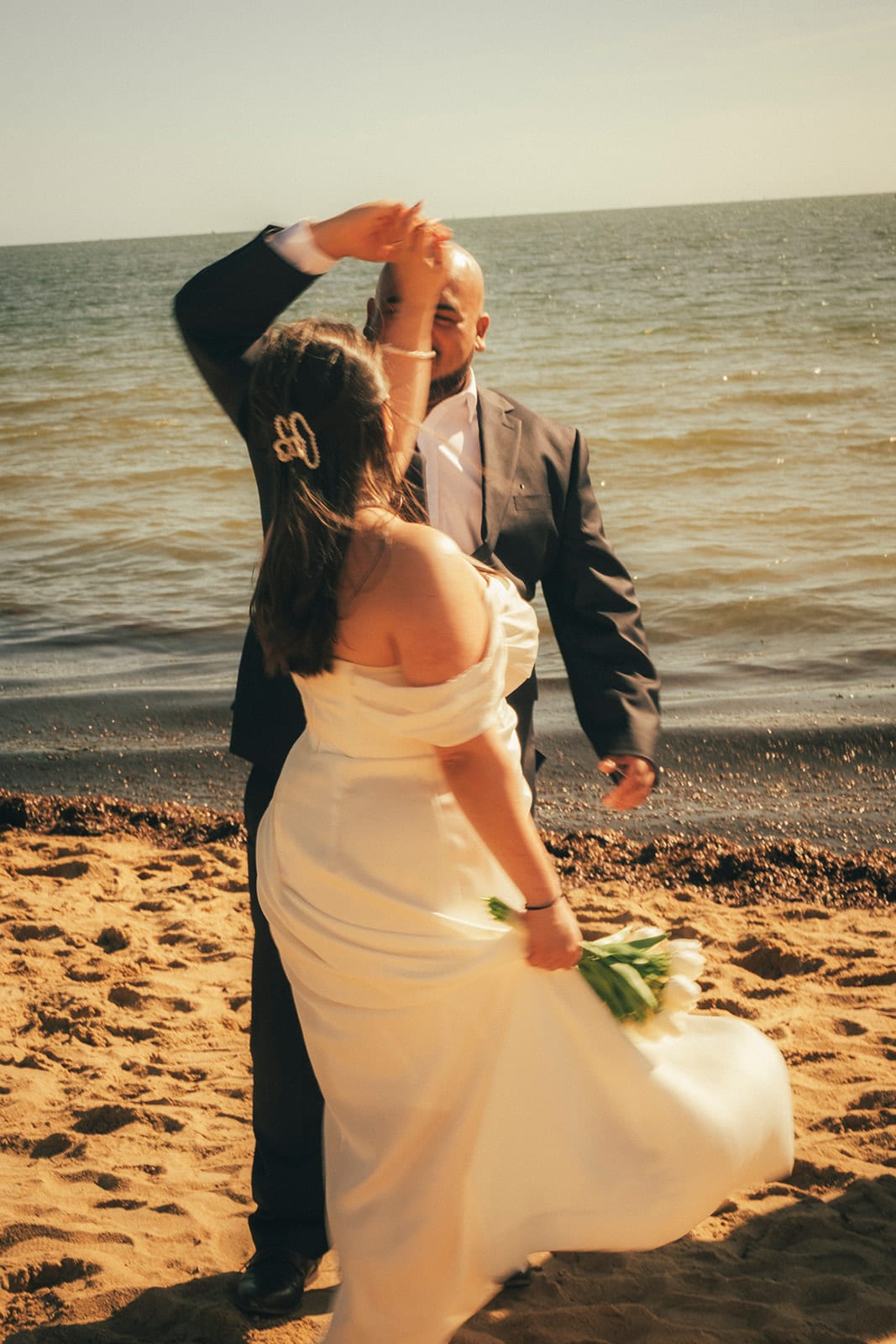 Diego twirling Martina on the sand at the water’s edge