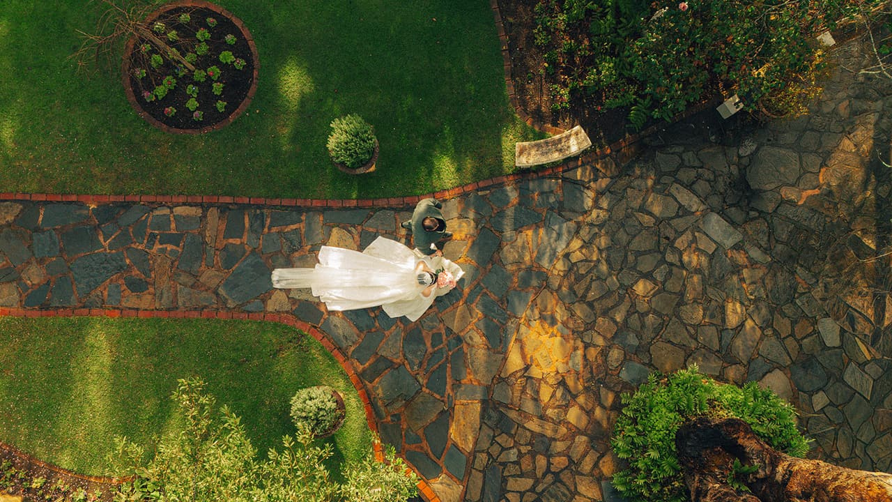 Aerial view looking straight down on Porscha and Jordan on a garden path at The Manor