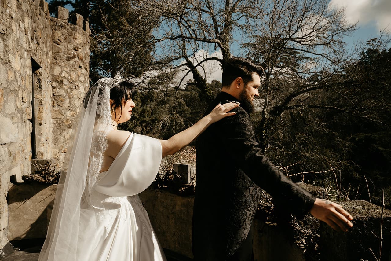 Porscha reaching for Jordan’s shoulder on the castle terrace before he turns around for the first look