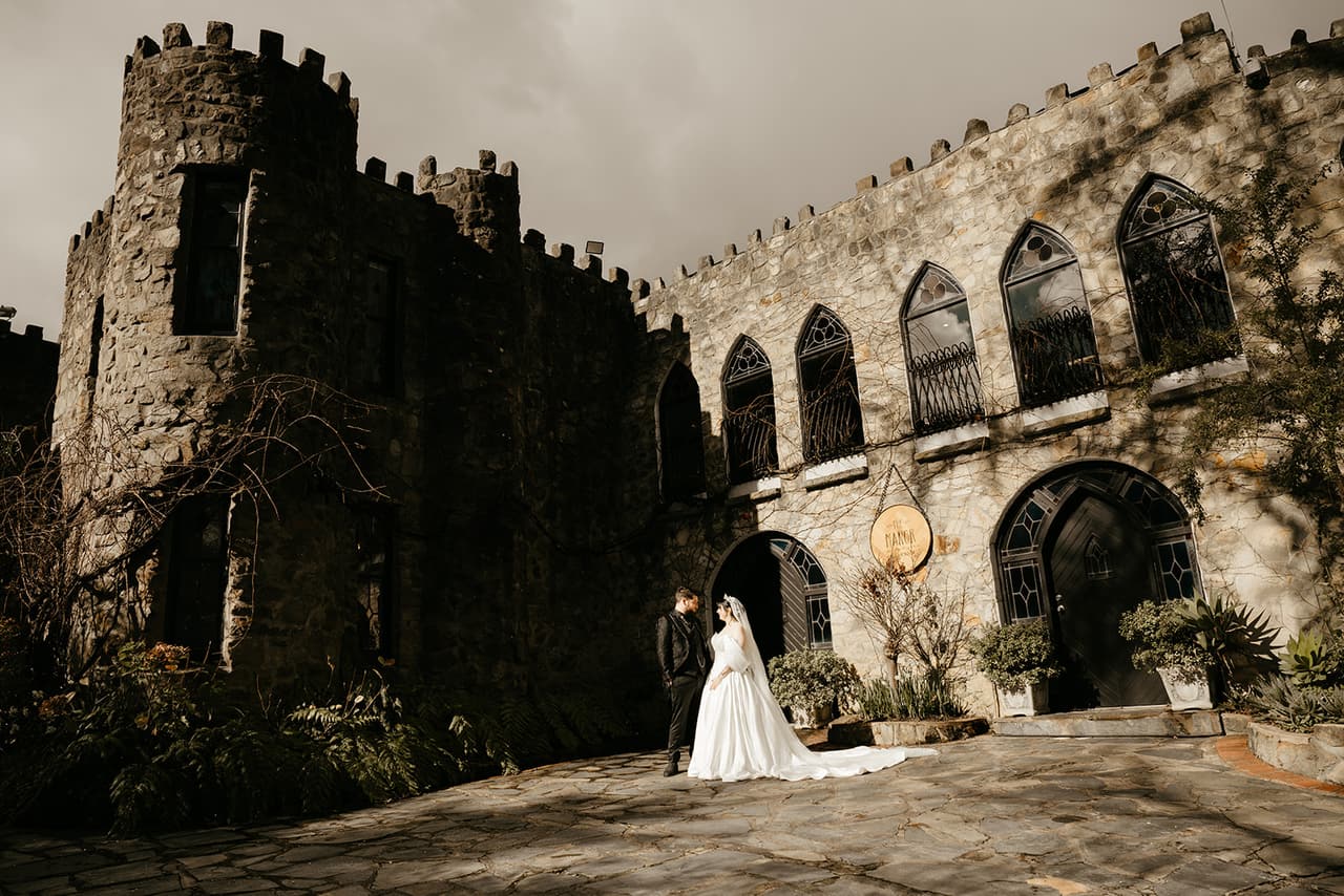 Porscha and Jordan small in the stone courtyard beneath the castle’s battlements and arched windows