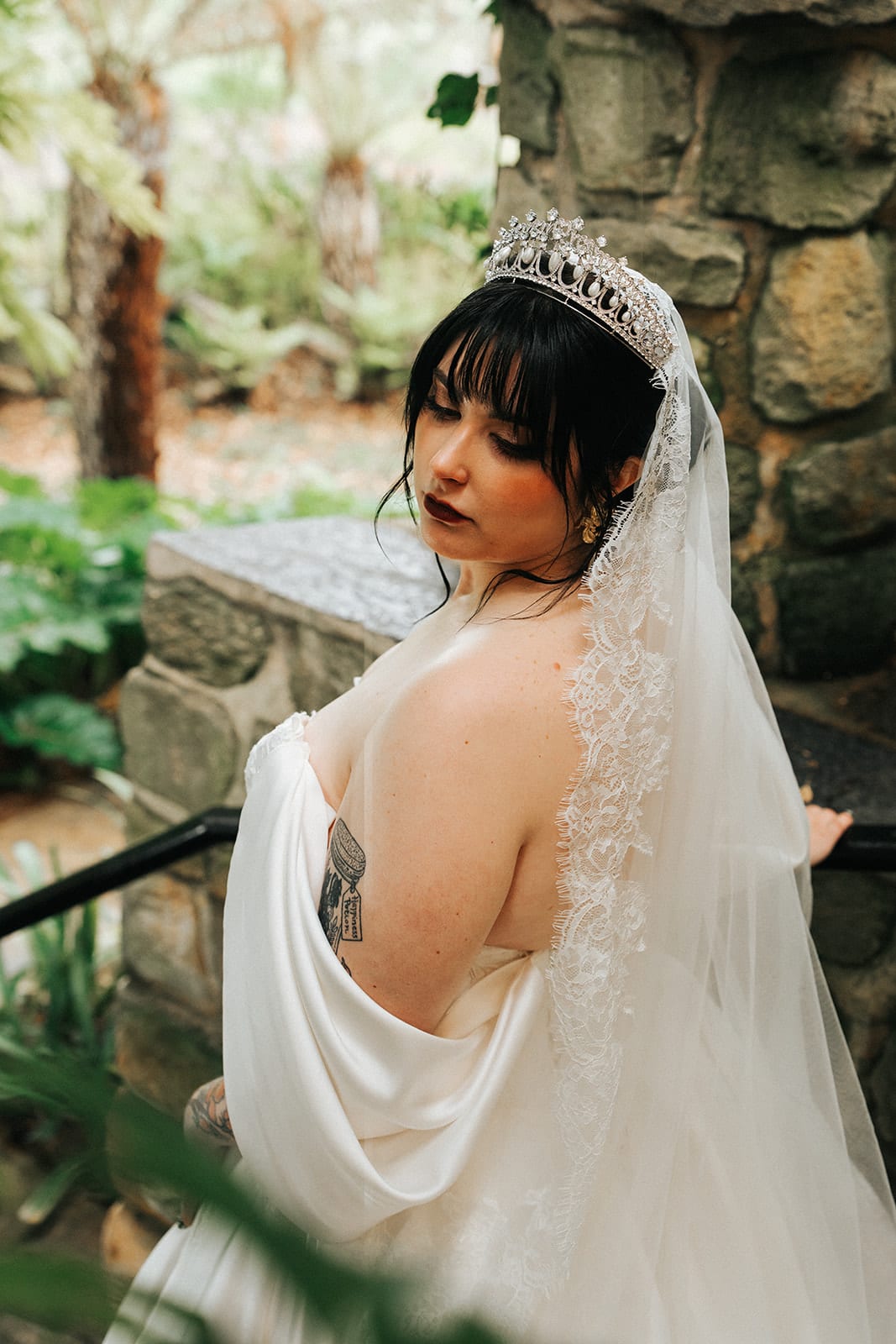 Porscha glancing back over her shoulder on the stone stairs, her veil trailing behind