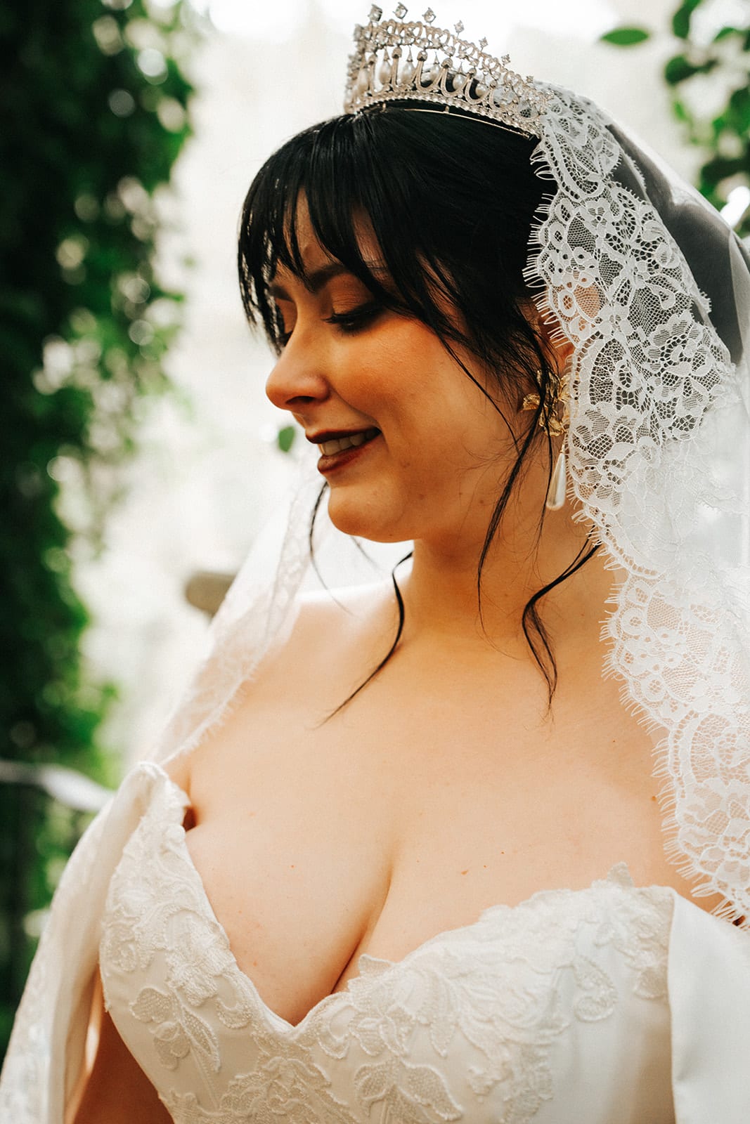 Porscha laughing in her tiara and veil, the garden soft behind her
