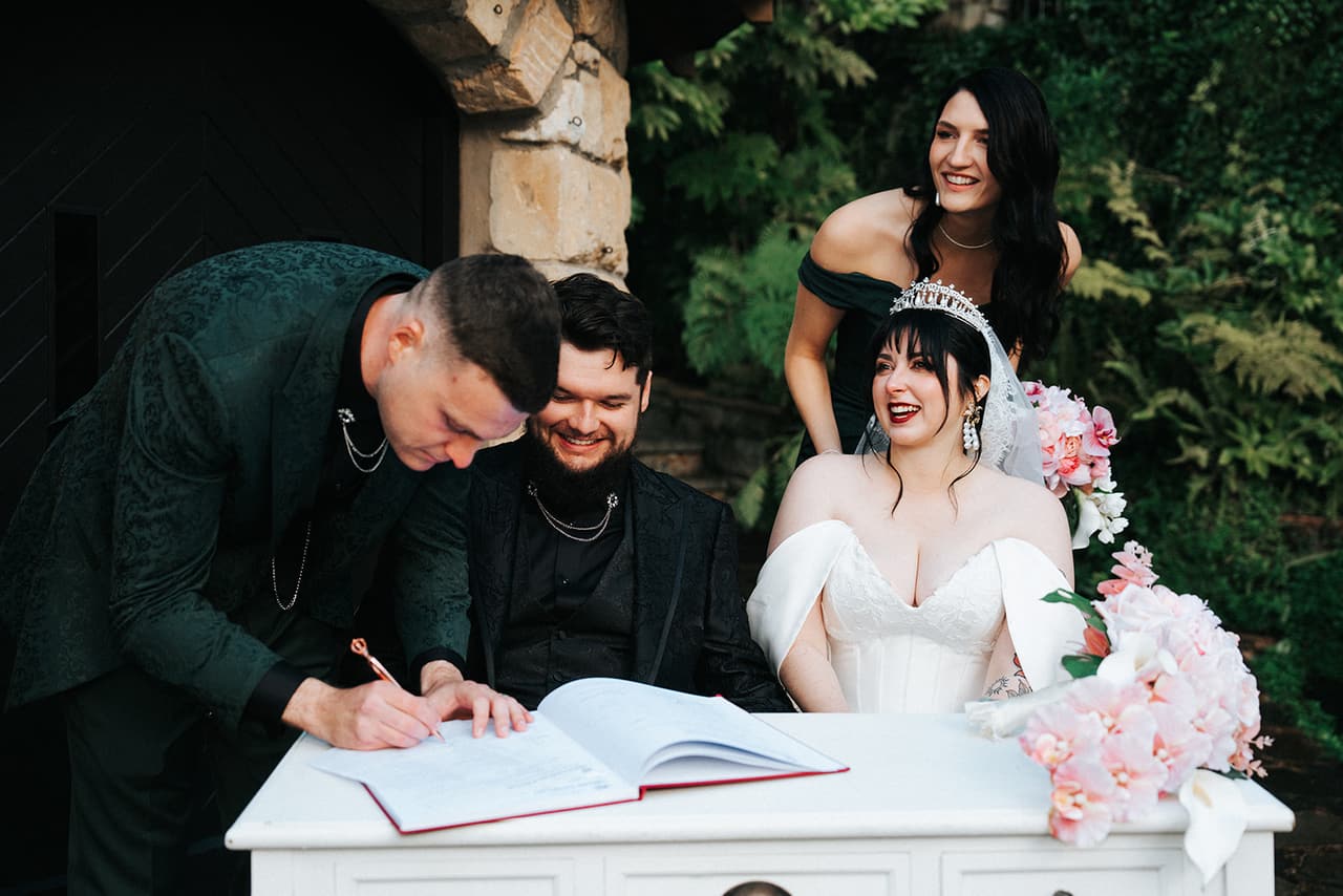 Porscha and Jordan laughing with their witnesses while the register is signed