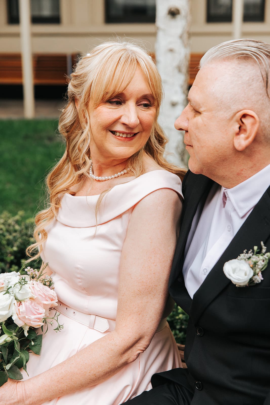 Terrie laughing as Jon leans in close in the courtyard garden
