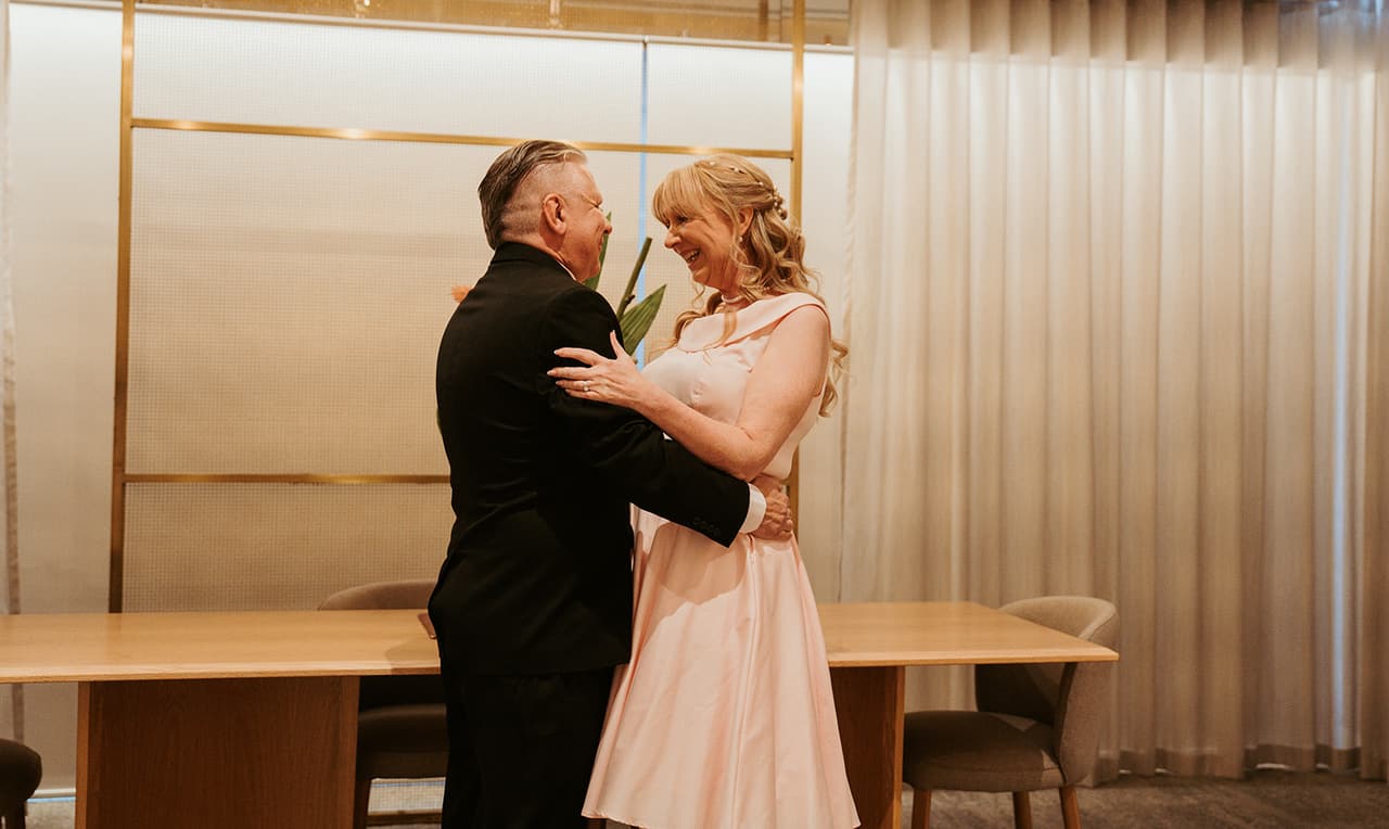 Terrie and Jon hugging after their vows in the registry room