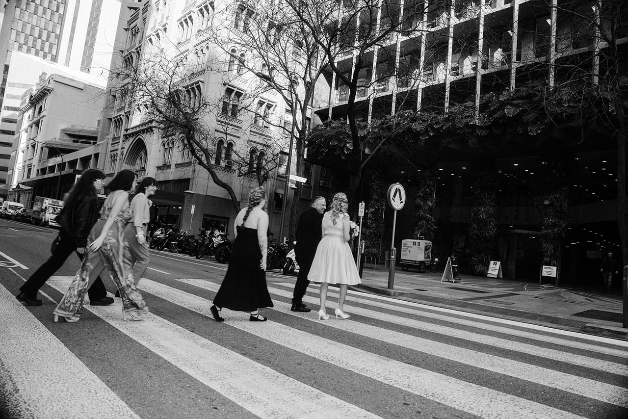 Black and white photo of Terrie, Jon and their guests crossing a city street